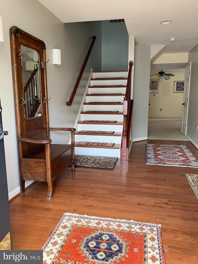 stairway with wood finished floors and baseboards