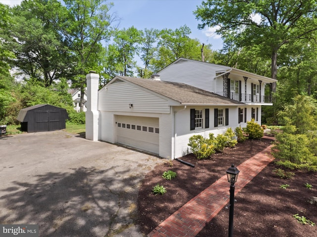 9301 Reef Ct, Alexandria, VA 22309 - view of front of house featuring a balcony, a storage shed, a garage, brick siding, and asphalt driveway