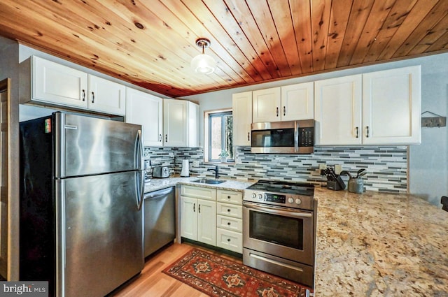 kitchen featuring white cabinetry, sink, light stone countertops, and appliances with stainless steel finishes