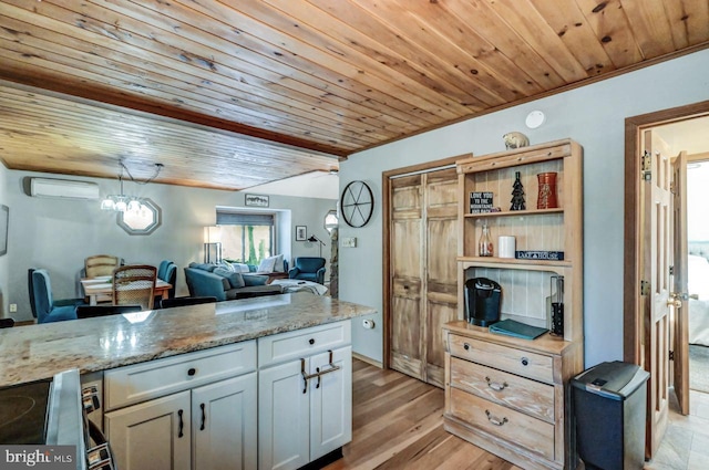 kitchen featuring wood ceiling, a wall mounted AC, light stone countertops, white cabinets, and light wood-type flooring