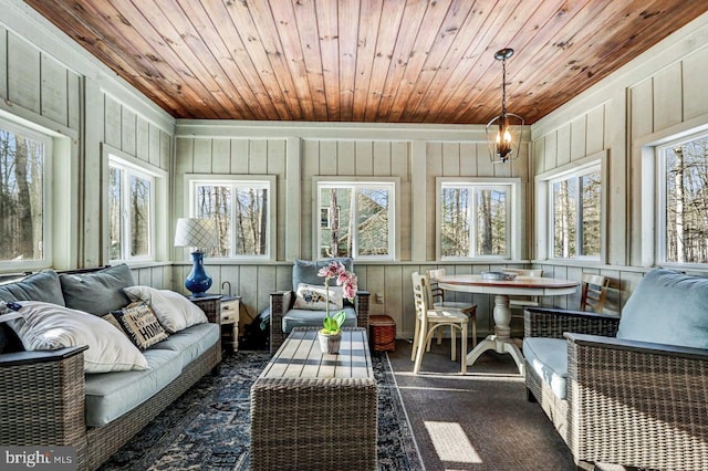 sunroom featuring breakfast area, wood ceiling, and plenty of natural light