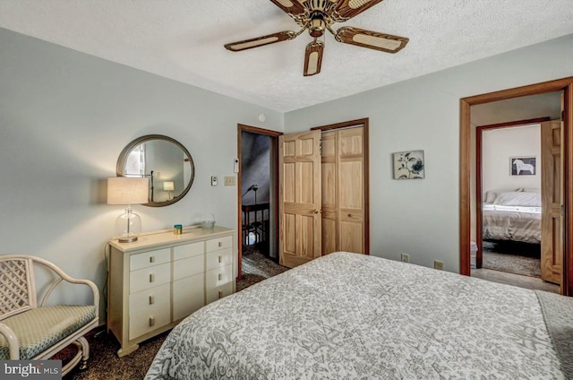 bedroom featuring ceiling fan, a textured ceiling, a closet, and dark colored carpet