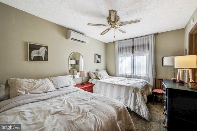 bedroom with ceiling fan, carpet, a wall unit AC, and a textured ceiling