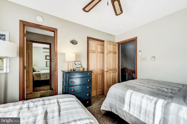 bedroom featuring ceiling fan, a wall unit AC, a closet, and dark colored carpet