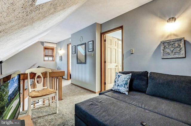 bedroom with light colored carpet, vaulted ceiling, a textured ceiling, and an AC wall unit