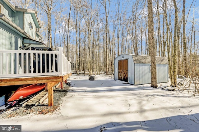 yard covered in snow featuring a shed