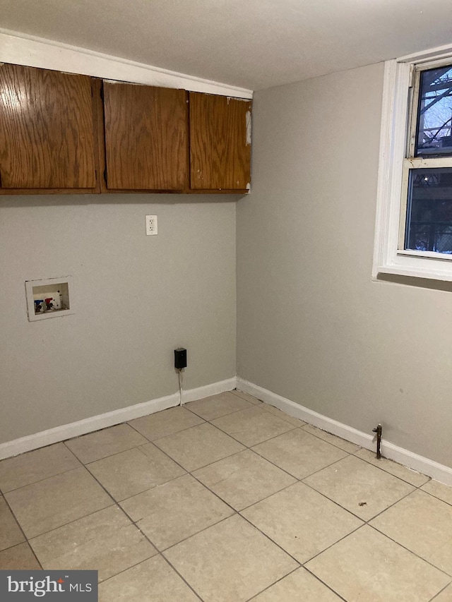 laundry room featuring cabinets, hookup for a washing machine, and light tile patterned floors