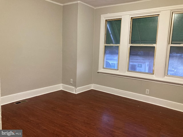 spare room featuring dark hardwood / wood-style flooring and ornamental molding