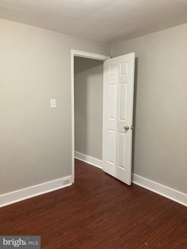 spare room with dark wood-type flooring