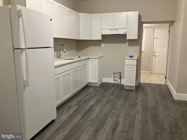 kitchen with white cabinetry, sink, dark hardwood / wood-style floors, and white fridge