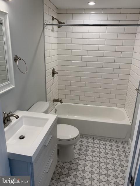 full bath featuring bathing tub / shower combination, toilet, and vanity