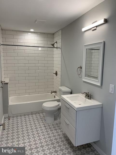 full bath featuring toilet,  shower combination, vanity, and baseboards