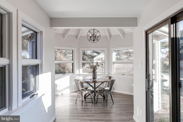 sunroom / solarium featuring an inviting chandelier and beam ceiling