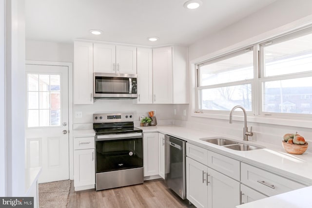 kitchen featuring sink, a wealth of natural light, stainless steel appliances, and white cabinets