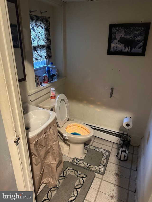 bathroom featuring tile patterned floors, toilet, sink, and a baseboard heating unit