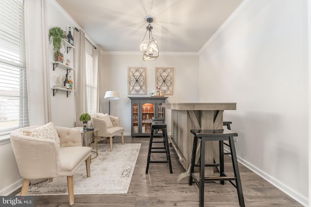 sitting room featuring dark wood-style floors, plenty of natural light, ornamental molding, and baseboards