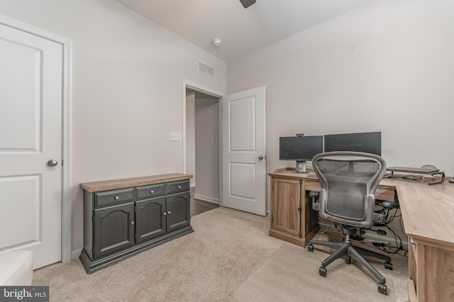 office space with light carpet, visible vents, and a ceiling fan