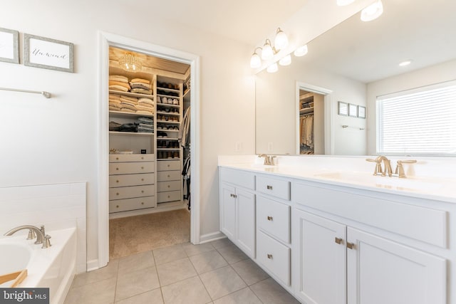 full bath featuring double vanity, tile patterned flooring, a walk in closet, and a sink