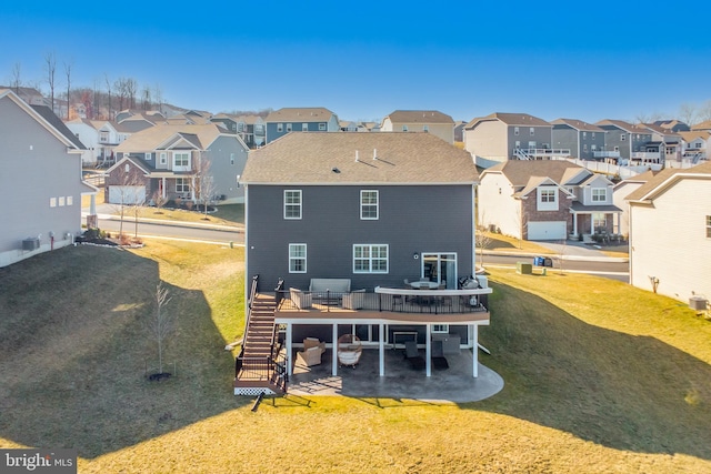 rear view of house featuring stairs, a yard, a wooden deck, and a residential view