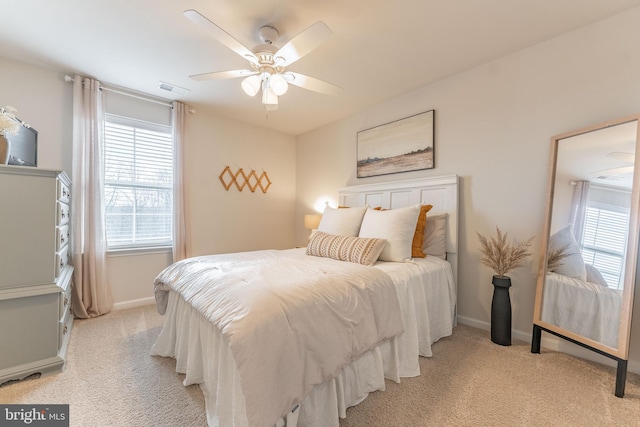 bedroom featuring baseboards, visible vents, ceiling fan, and light colored carpet