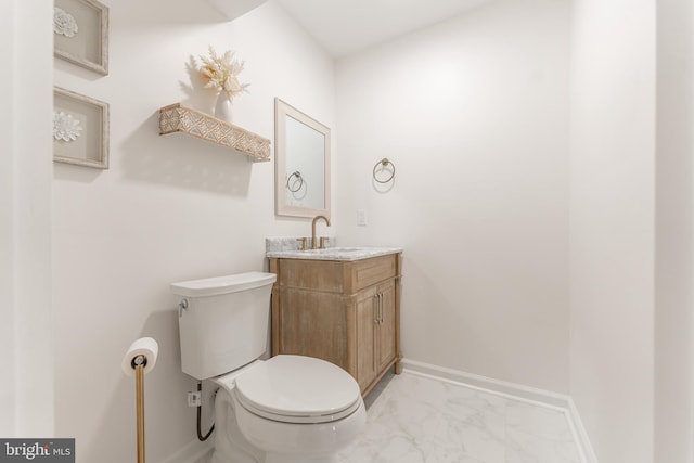 bathroom featuring marble finish floor, vanity, toilet, and baseboards