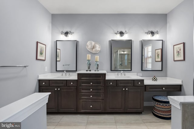 full bath with double vanity, a sink, and a shower with door