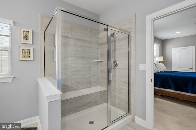 ensuite bathroom with a stall shower, baseboards, and ensuite bathroom