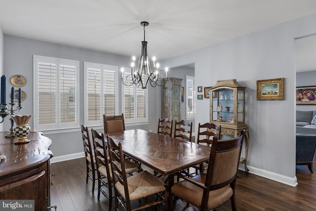 dining area featuring an inviting chandelier, baseboards, and wood finished floors