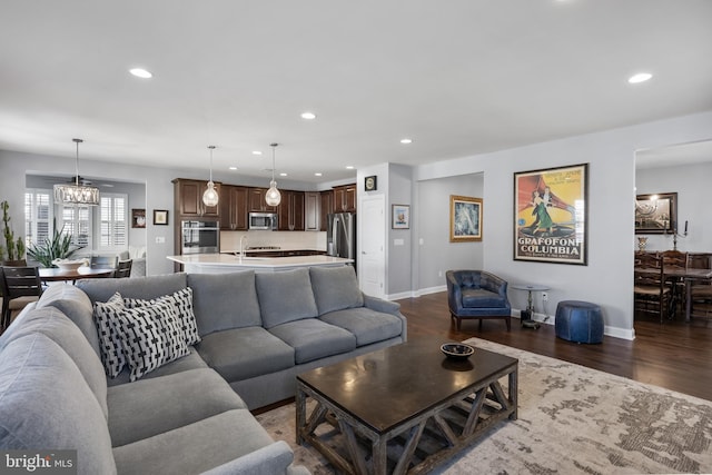 living room with recessed lighting, a notable chandelier, dark wood finished floors, and baseboards