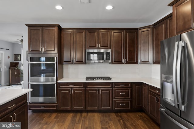 kitchen with dark wood-style floors, light countertops, appliances with stainless steel finishes, and dark brown cabinets