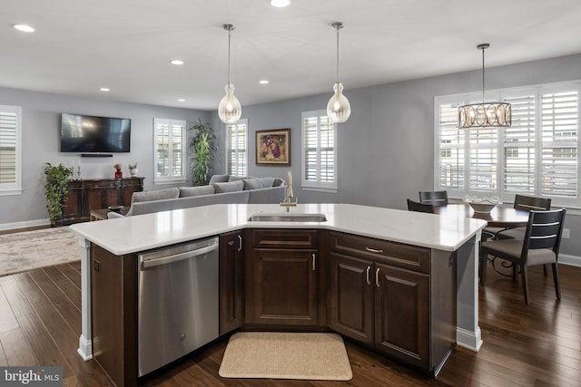 kitchen with dark wood-type flooring, light countertops, a sink, and stainless steel dishwasher