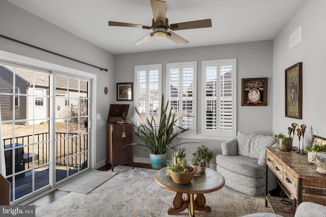 living area featuring visible vents, ceiling fan, and baseboards