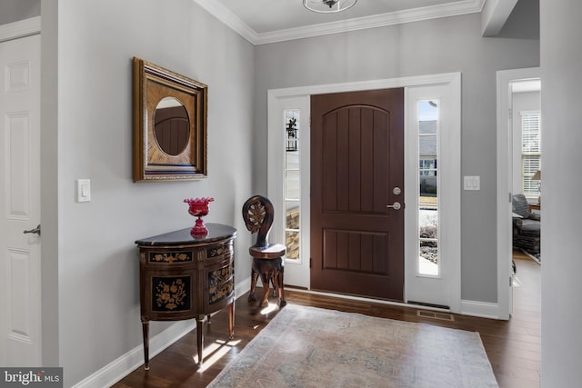 foyer featuring dark wood-style floors, baseboards, visible vents, and crown molding