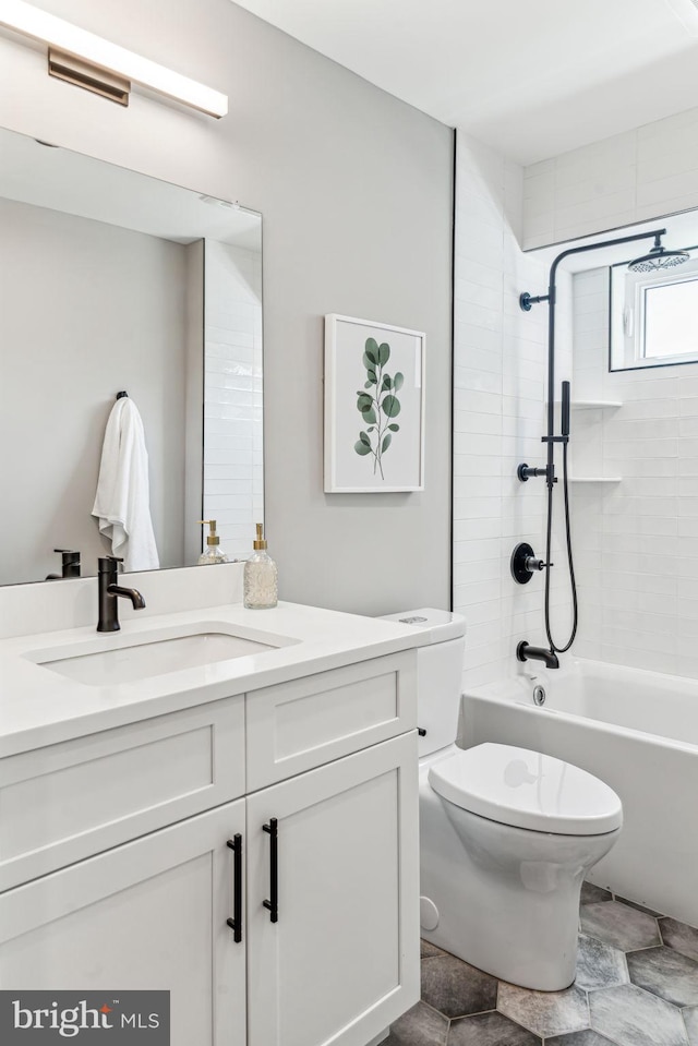 full bathroom with tiled shower / bath, vanity, and toilet