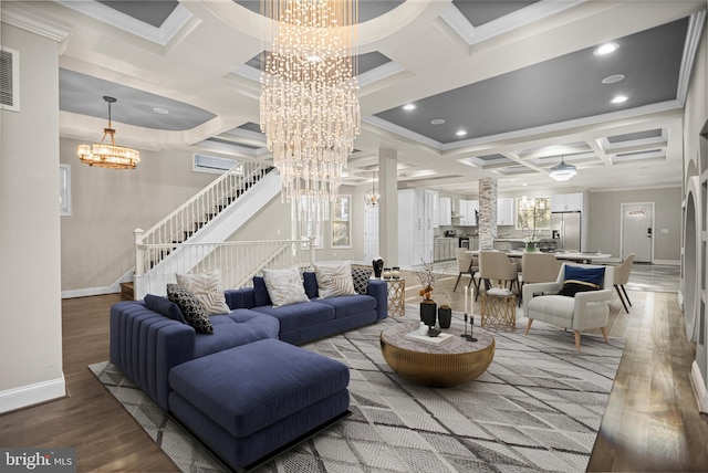 living room with coffered ceiling, hardwood / wood-style floors, crown molding, and a chandelier