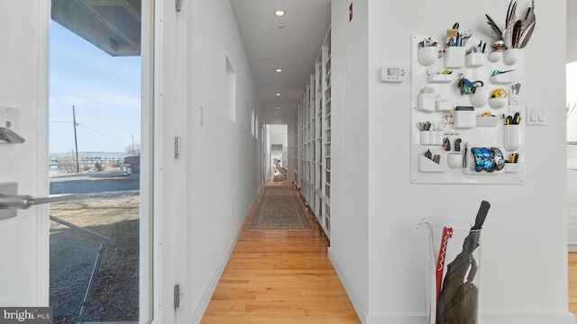 hallway with light wood finished floors, recessed lighting, and baseboards