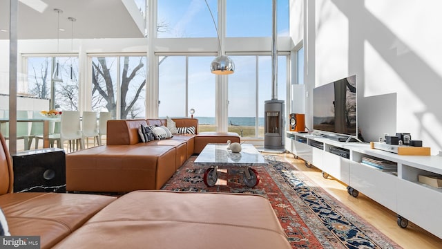 living room with light wood-style floors and a towering ceiling