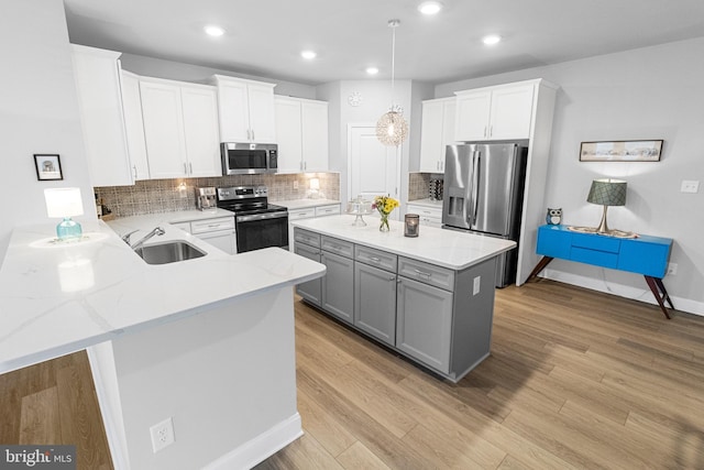 kitchen with appliances with stainless steel finishes, gray cabinets, white cabinets, and a sink