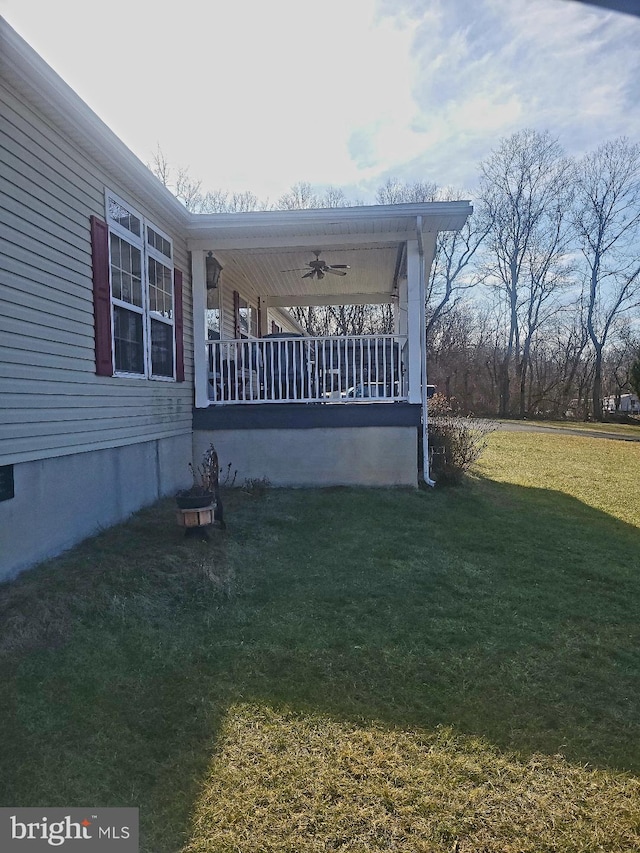 view of side of home with a lawn, ceiling fan, and a porch