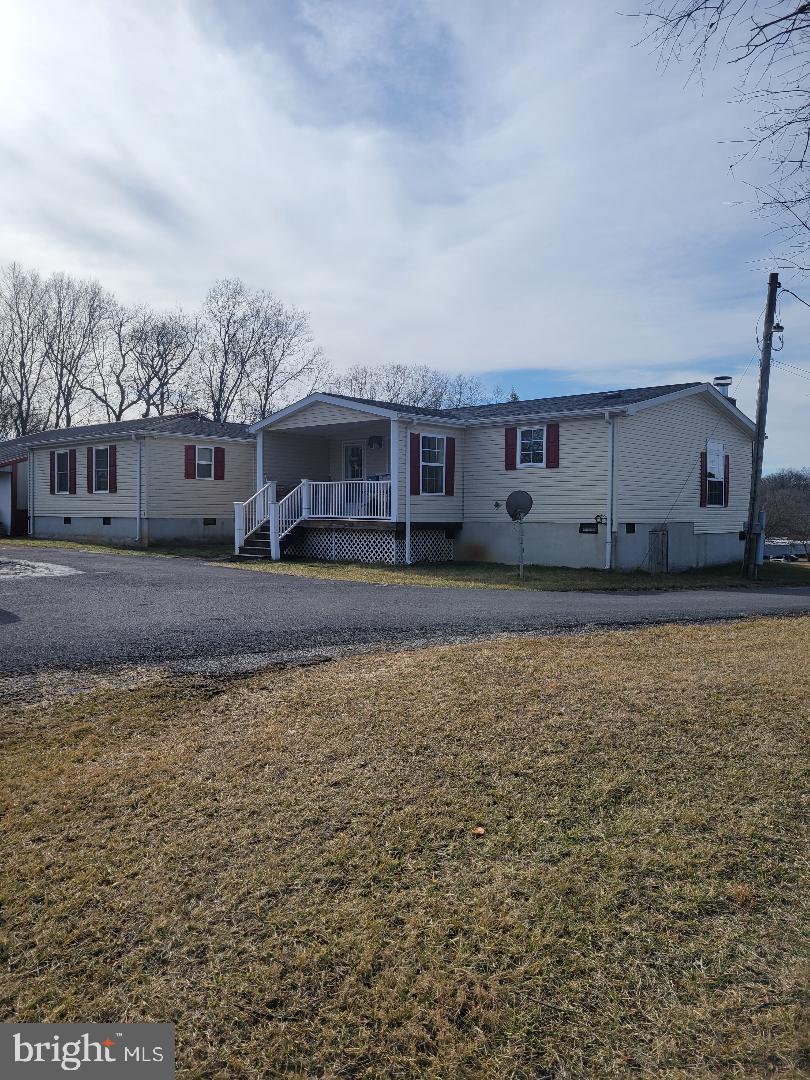 manufactured / mobile home with a front lawn and covered porch