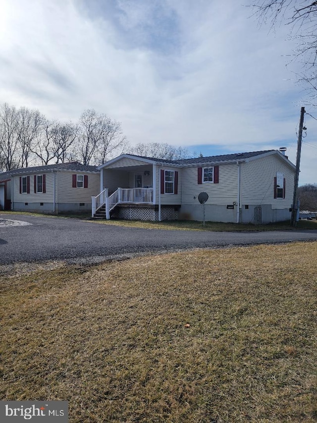 manufactured / mobile home with a front lawn and covered porch