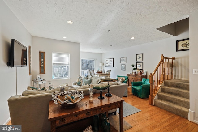 living room with a textured ceiling and light hardwood / wood-style floors