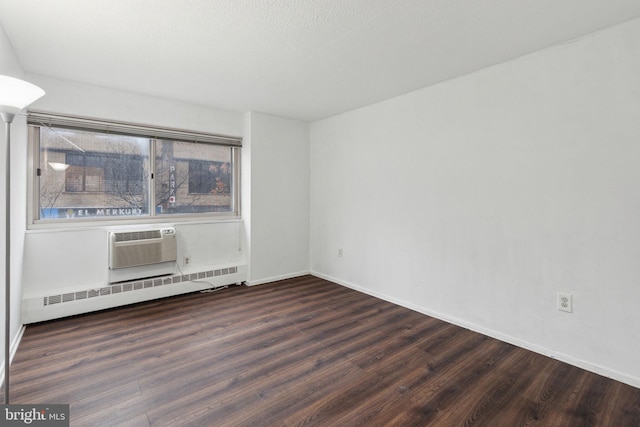 spare room featuring a baseboard radiator, dark hardwood / wood-style floors, and a textured ceiling