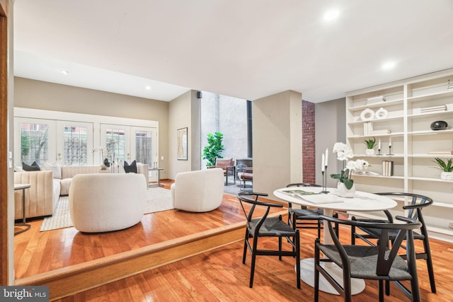 dining space with recessed lighting, french doors, a wood stove, and hardwood / wood-style flooring