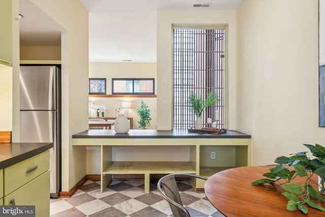 office area featuring baseboards, visible vents, and built in study area