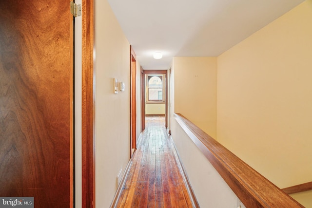 hallway with baseboards and hardwood / wood-style flooring