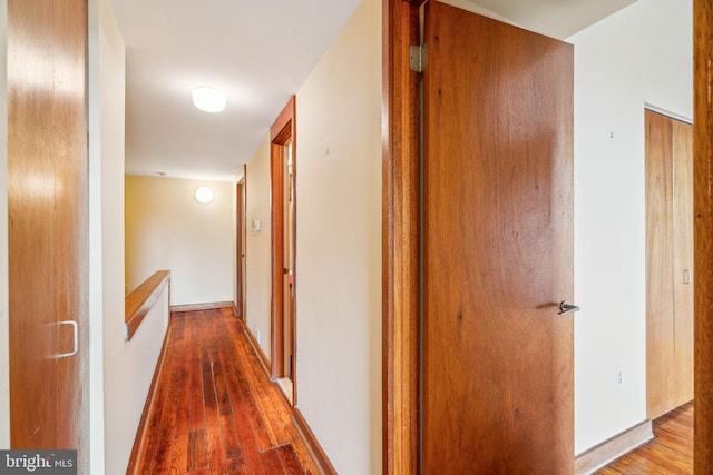 hallway with baseboards and hardwood / wood-style flooring