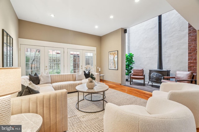 living room with recessed lighting, french doors, wood finished floors, and a wood stove