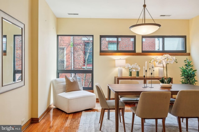 dining room with visible vents, baseboards, and wood finished floors