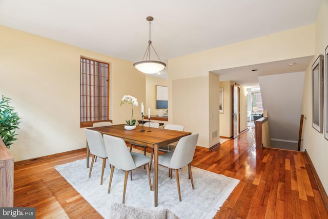 dining area with visible vents, baseboards, and hardwood / wood-style floors